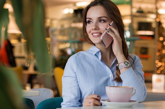 mladá žena telefonuje u kávy